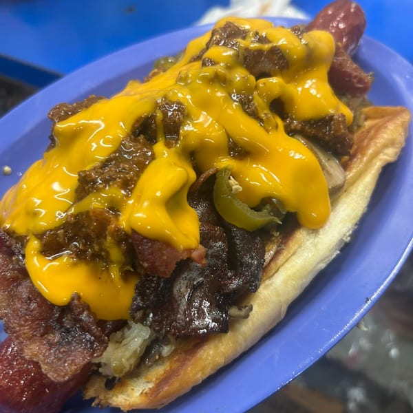 A loaded hot dog from Nicky Ds Crowley, topped with chili, melted cheese, bacon, and peppers.